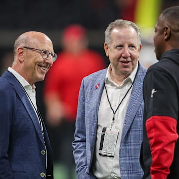 Tampa Bay Buccaneers owner Joel Glazer and owner Bryan Glazer talk to Atlanta Falcons head coach Raheem Morris.