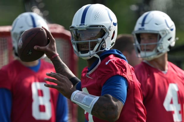 Football player Anthony Richardson throws the ball at practice in a red jersey.