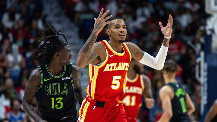 Nov 4, 2023; New Orleans, Louisiana, USA;  Atlanta Hawks guard Dejounte Murray (5) reacts to making a three point basket against New Orleans Pelicans guard Kira Lewis Jr. (13) during the second half at Smoothie King Center.