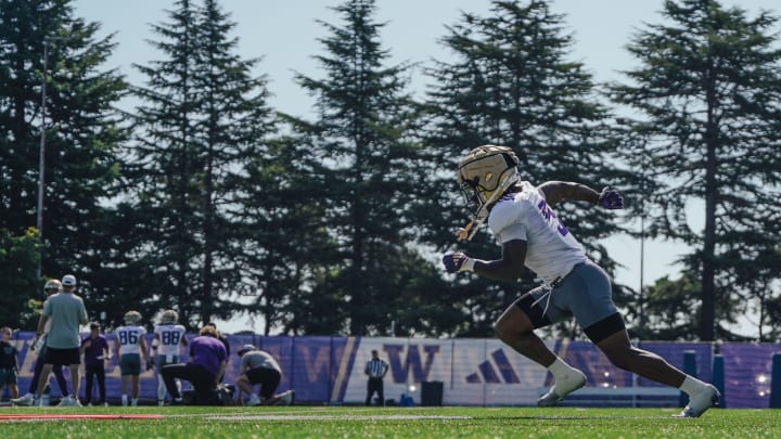 Giles Jackson runs against a backdrop of trees on the East field.