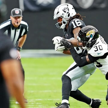 Nov 2, 2025; Paradise, Nevada, USA; Jacksonville Jaguars cornerback Montaric Brown (30) tackles Las Vegas Raiders wide receiver Jakobi Meyers (16) during the second half at Allegiant Stadium. Mandatory Credit: Stephen R. Sylvanie-Imagn Images