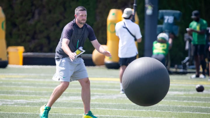 Oregon head coach Dan Lanning throws a large ball at returners during kick return drills during practice with the Oregon Ducks Friday, Aug. 9, 2024 at the Hatfield-Dowlin Complex in Eugene, Ore.