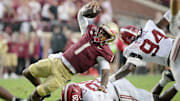 Florida State Seminoles quarterback Tommy Castellanos loses his footing against Alabama Crimson Tide linebacker Jah-Marien Latham