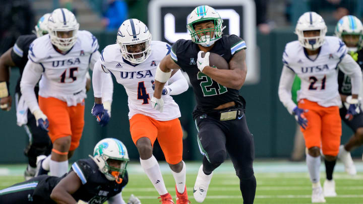 Nov 24, 2023; New Orleans, Louisiana, USA; Tulane Green Wave running back Makhi Hughes (21) runs against UTSA Roadrunners running back Kevorian Barnes (4) during the first half at Yulman Stadium. 