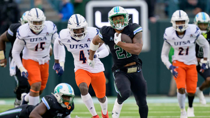 Nov 24, 2023; New Orleans, Louisiana, USA; Tulane Green Wave running back Makhi Hughes (21) runs against UTSA Roadrunners running back Kevorian Barnes (4) during the first half at Yulman Stadium. 