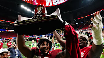 Dec 2, 2023; Atlanta, GA, USA; Alabama Crimson Tide offensive lineman Kadyn Proctor (74) celebrates with the trophy after defeating the Georgia Bulldogs in the SEC Championship at Mercedes-Benz Stadium. Mandatory Credit: John David Mercer-USA TODAY Sports
