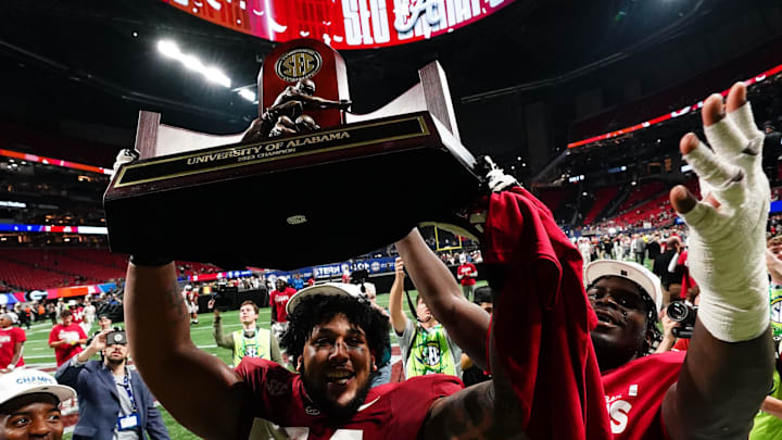 Dec 2, 2023; Atlanta, GA, USA; Alabama Crimson Tide offensive lineman Kadyn Proctor (74) celebrates with the trophy after defeating the Georgia Bulldogs in the SEC Championship at Mercedes-Benz Stadium. Mandatory Credit: John David Mercer-USA TODAY Sports