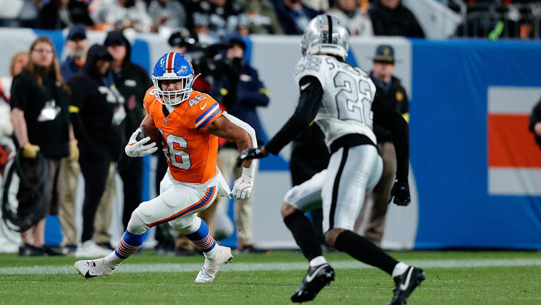 Nov 6, 2025; Denver, Colorado, USA; Denver Broncos fullback Adam Prentice (46) runs the ball against Las Vegas Raiders cornerback Eric Stokes (22) in the third quarter at Empower Field at Mile High. Mandatory Credit: Isaiah J. Downing-Imagn Images