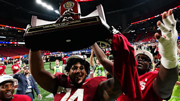 Dec 2, 2023; Atlanta, GA, USA; Alabama Crimson Tide offensive lineman Kadyn Proctor (74) celebrates with the trophy after defeating the Georgia Bulldogs in the SEC Championship at Mercedes-Benz Stadium. Mandatory Credit: John David Mercer-Imagn Images