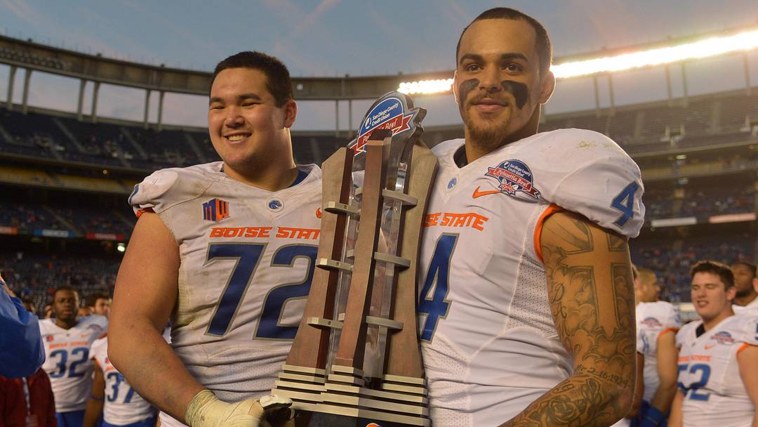 Boise State offensive lineman Marcus Henry (72) and safety Darian Thompson hold the Poinsettia Bowl trophy. 