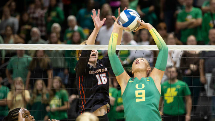 Oregon's Hannah Pukis, right, sets the ball against Oregon State's Lauren Rumel during the third set in Eugene Friday, Sept. 22, 2023.