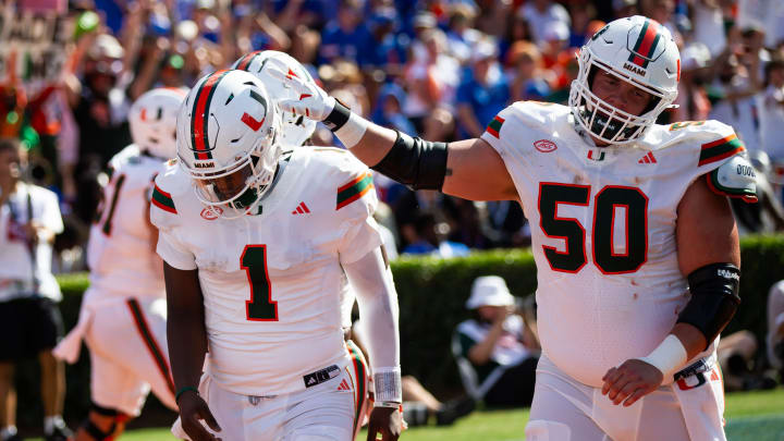 Miami Hurricanes quarterback Cam Ward (1) is congratulated by Miami Hurricanes center Zach Carpenter (50) after scoring a touchdown during the season opener at Ben Hill Griffin Stadium in Gainesville, FL on Saturday, August 31, 2024 against the University of Miami Hurricanes in the first half. Miami lead 24-10 at the half. [Doug Engle/Gainesville Sun]