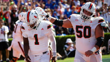 Miami Hurricanes quarterback Cam Ward (1) is congratulated by Miami Hurricanes center Zach Carpenter (50) after scoring a touchdown during the season opener at Ben Hill Griffin Stadium in Gainesville, FL on Saturday, August 31, 2024 against the University of Miami Hurricanes in the first half. Miami lead 24-10 at the half. [Doug Engle/Gainesville Sun]