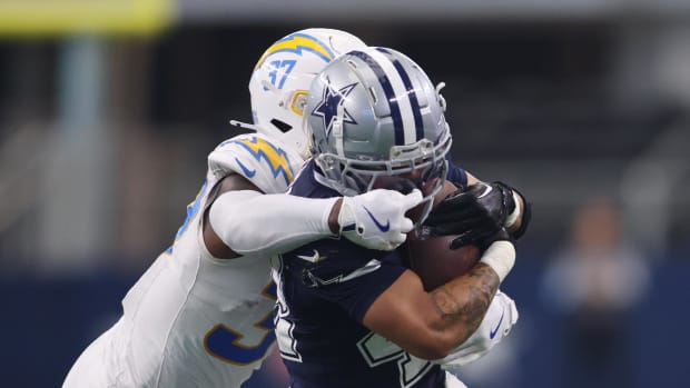 Los Angeles Chargers safety Thomas Harper (37) grabs the facemask of Dallas Cowboys running back Deuce Vaughn