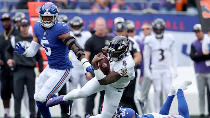 Oct 16, 2022; East Rutherford, New Jersey, USA; Baltimore Ravens quarterback Lamar Jackson (8) runs with the ball against New York Giants safety Julian Love (20) and defensive end Kayvon Thibodeaux (5) during the first quarter at MetLife Stadium. Mandatory Credit: Brad Penner-Imagn Images