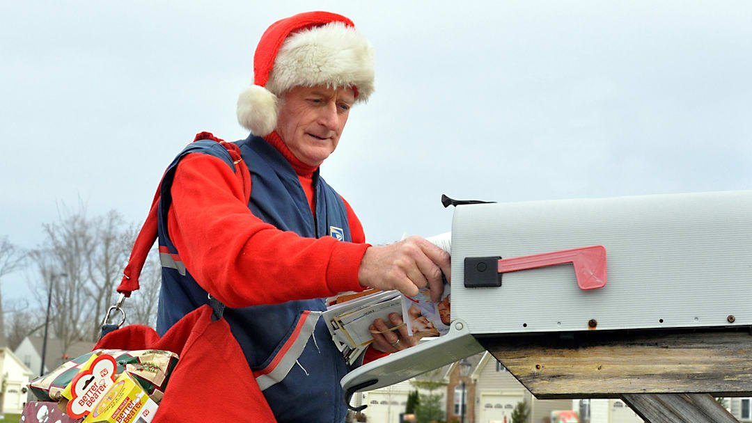 A mail carrier during Christmastime dressed up in festive gear