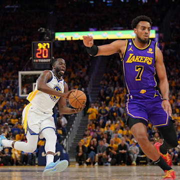 Golden State Warriors forward Draymond Green (23) passes the ball between Los Angeles Lakers center Tristan Thompson (9) and guard Troy Brown Jr. (7) in the fourth quarter during game two of the 2023 NBA playoffs at the Chase Center.