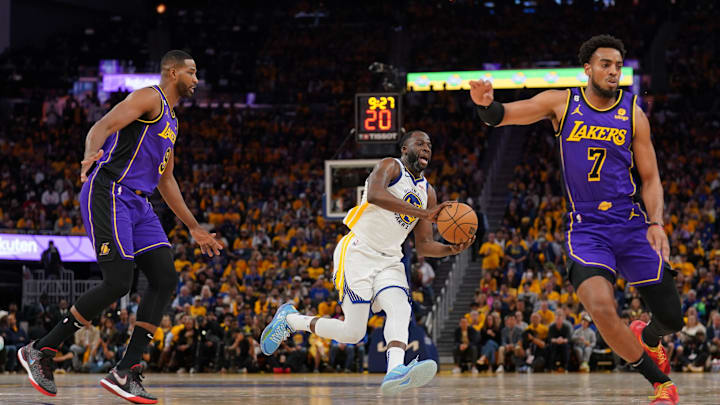 Golden State Warriors forward Draymond Green (23) passes the ball between Los Angeles Lakers center Tristan Thompson (9) and guard Troy Brown Jr. (7) in the fourth quarter during game two of the 2023 NBA playoffs at the Chase Center.