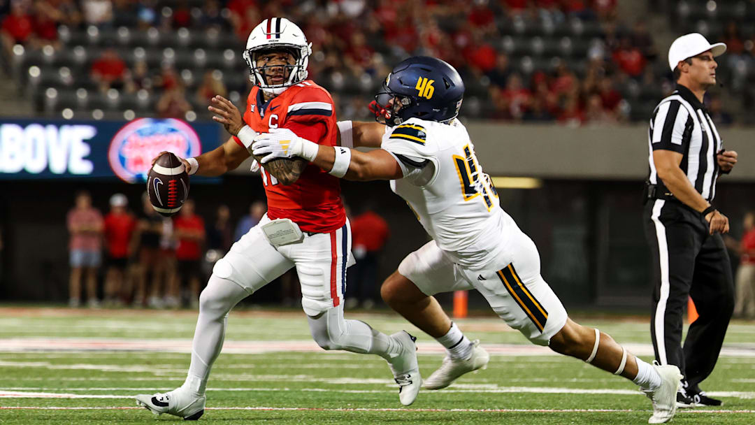 Sep 7, 2024; Tucson, Arizona, USA; Arizona Wildcats quarterback Noah Fifita (11) rolls out to pass against Northern Arizona Lumberjacks linebacker Tommy Ellis (46) during first quarter at Arizona Stadium. 