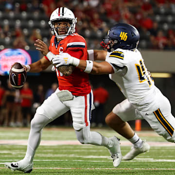 Sep 7, 2024; Tucson, Arizona, USA; Arizona Wildcats quarterback Noah Fifita (11) rolls out to pass against Northern Arizona Lumberjacks linebacker Tommy Ellis (46) during first quarter at Arizona Stadium. 