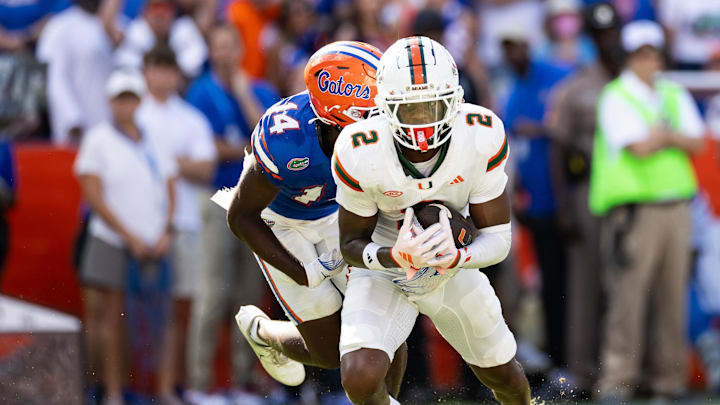 Aug 31, 2024; Gainesville, Florida, USA; Miami Hurricanes wide receiver Isaiah Horton (2) runs with the ball from Florida Gators defensive back Jordan Castell (14) during the first half at Ben Hill Griffin Stadium. Mandatory Credit: Matt Pendleton-Imagn Images