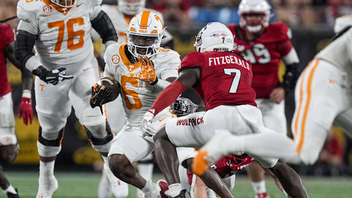 Sep 7, 2024; Charlotte, North Carolina, USA; Tennessee Volunteers running back Dylan Sampson (6) runs as North Carolina State Wolfpack safety Bishop Fitzgerald (7) defends during the second half at the Dukes Mayo Classic at Bank of America Stadium. Mandatory Credit: Jim Dedmon-Imagn Images