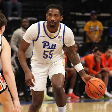 Feb 18, 2025; Pittsburgh, Pennsylvania, USA; Pittsburgh Panthers forward Zack Austin (55) dribbles against Syracuse Orange forward Petar Majstorovic (6) during the second half at the Petersen Events Center. Mandatory Credit: Charles LeClaire-Imagn Images