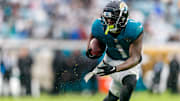Dec 29, 2024; Jacksonville, Florida, USA; Jacksonville Jaguars running back Travis Etienne Jr. (1) runs the ball against the Tennessee Titans during the second quarter at EverBank Stadium. Mandatory Credit: Morgan Tencza-Imagn Images