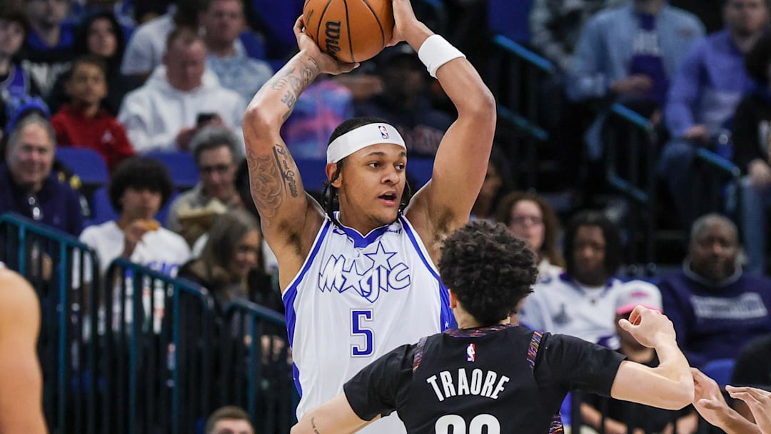 Feb 5, 2026; Orlando, Florida, USA; Orlando Magic forward Paolo Banchero (5) looks to pass in front of Brooklyn Nets guard Nolan Traore (88) during the first quarter at Kia Center. Mandatory Credit: Mike Watters-Imagn Images