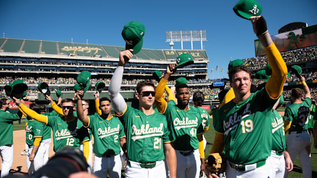 Sep 26, 2024; Oakland, California, USA; Athletics players tip their caps to crowd after the final game at Oakland Coliseum.