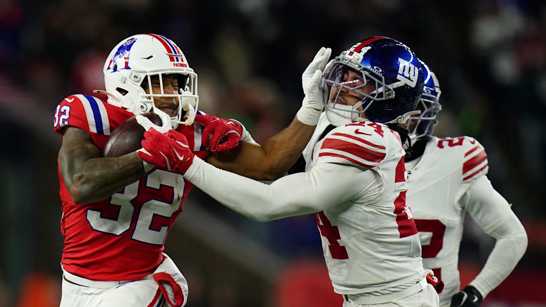 Dec 1, 2025; Foxborough, Massachusetts, USA; New England Patriots running back TreVeyon Henderson (32) runs the ball against New York Giants safety Dane Belton (24) during the fourth quarter at Gillette Stadium.  
