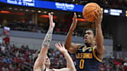 Mar 5, 2025; Louisville, Kentucky, USA;  California Golden Bears guard Jeremiah Wilkinson (0) shoots against Louisville Cardinals guard Reyne Smith (6) during the first half at KFC Yum! Center. Mandatory Credit: Jamie Rhodes-Imagn Images