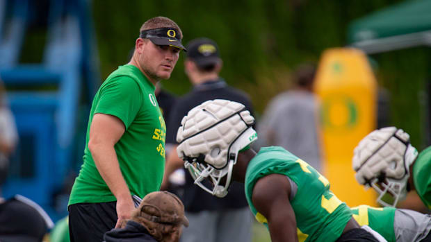 Oregon defensive coordinator Tosh Lupoi watches over practice with the Ducks
