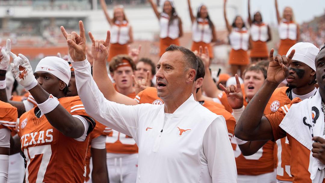  Texas Longhorns head coach Steve Sarkisian and players hold up their horns with the fans during the singing of the Eyes of Texas. 