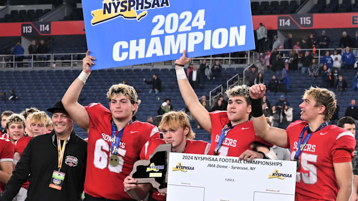Somers players hold their plaque and signs after beating Whitesboro in the NYSPHSAA Class A football championship game for the second year in a row Friday, Dec. 6, 2024, at the JMA Wireless Dome in Syracuse, New York. Somers players hold their plaque and signs after beating Whitesboro in the NYSPHSAA Class A football championship game for the second year in a row Friday, Dec. 6, 2024, at the JMA Wireless Dome in Syracuse, New York.