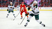 Apr 11, 2025; Calgary, Alberta, CAN; Minnesota Wild center Yakov Trenin (13) shoots the puck against the Calgary Flames during the first period at Scotiabank Saddledome. Mandatory Credit: Sergei Belski-Imagn Images