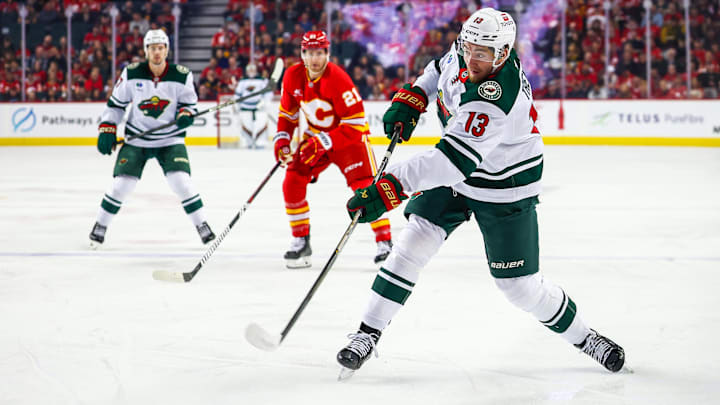 Apr 11, 2025; Calgary, Alberta, CAN; Minnesota Wild center Yakov Trenin (13) shoots the puck against the Calgary Flames during the first period at Scotiabank Saddledome. Mandatory Credit: Sergei Belski-Imagn Images