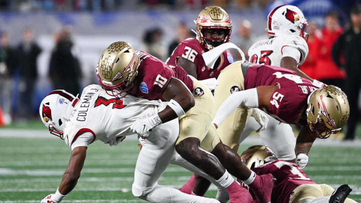 Dec 2, 2023; Charlotte, NC, USA; Louisville Cardinals wide receiver Kevin Coleman (3) is tackled by Florida State Seminoles linebacker DJ Lundy (10) in the first quarter at Bank of America Stadium. Mandatory Credit: Bob Donnan-USA TODAY Sports