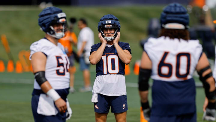 Jul 26, 2024; Englewood, CO, USA; Denver Broncos quarterback Bo Nix (10) and center Alex Forsyth (54) and center Luke Wattenberg (60) during training camp at Broncos Park Powered by CommonSpirit. 