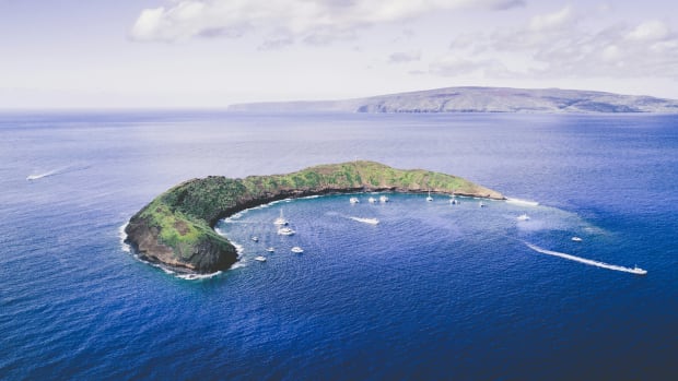 A drone's view of a cove where boats park for people to snorkel.