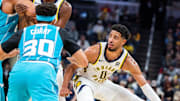 Oct 17, 2024; Indianapolis, Indiana, USA; Indiana Pacers guard Tyrese Haliburton (0) dribbles the ball while Charlotte Hornets guard Seth Curry (30) defends in the first half at Gainbridge Fieldhouse. Mandatory Credit: Trevor Ruszkowski-Imagn Images