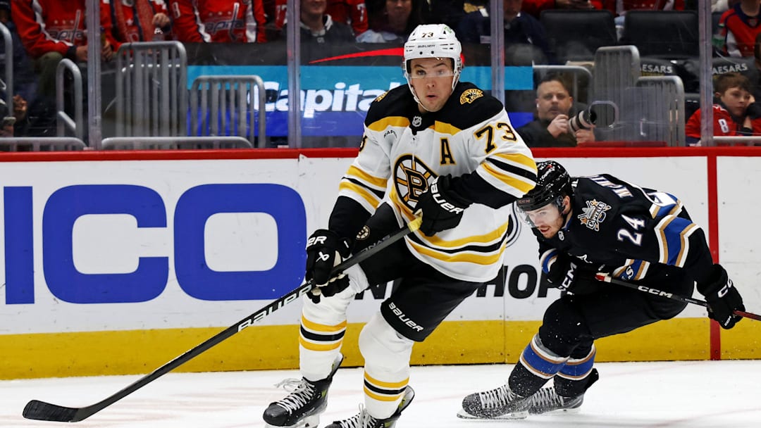 Dec 31, 2024; Washington, District of Columbia, USA; Boston Bruins defenseman Charlie McAvoy (73) skates with the puck against Washington Capitals center Connor McMichael (24) at Capital One Arena. Mandatory Credit: Peter Casey-Imagn Images