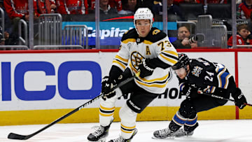 Dec 31, 2024; Washington, District of Columbia, USA; Boston Bruins defenseman Charlie McAvoy (73) skates with the puck against Washington Capitals center Connor McMichael (24) at Capital One Arena. Mandatory Credit: Peter Casey-Imagn Images