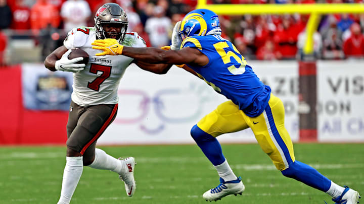 Jan 23, 2022; Tampa, Florida, USA; Tampa Bay Buccaneers running back Leonard Fournette (7) runs the ball against Los Angeles Rams outside linebacker Justin Hollins (58) during the second half in a NFC Divisional playoff football game at Raymond James Stadium.