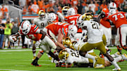 Nov 11, 2017; Miami Gardens, FL, USA; Miami Hurricanes quarterback DeeJay Dallas (13) dives into the end zone to score a touchdown against the Notre Dame Fighting Irish during the second half at Hard Rock Stadium. Mandatory Credit: Jasen Vinlove-Imagn Images