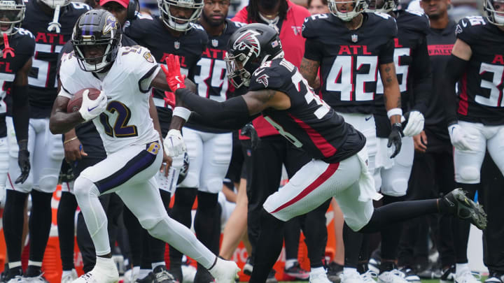 Baltimore Ravens wide receiver Malik Cunningham (12) gains yards after a second-quarter catch defended by Atlanta Falcons safety Tre Tarpley III (38) at M&T Bank Stadium.