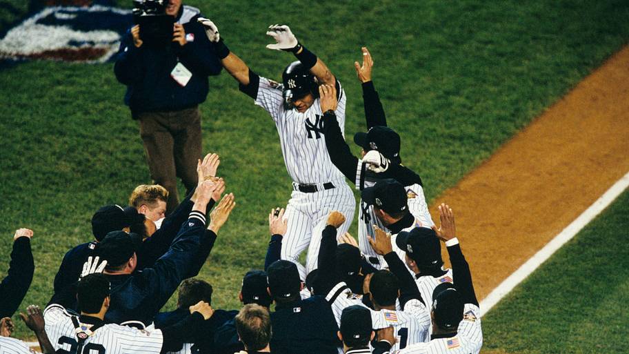 Derek Jeter is mobbed by teammates after hitting a game winning home run in Game 4 of the 2001 World Series.