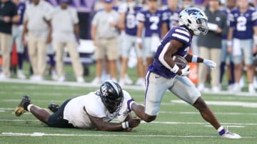 Sep 23, 2023; Manhattan, Kansas, USA; Kansas State Wildcats running back DJ Giddens (31) runs away from UCF Knights defensive tackle Lee Hunter (2) during the first quarter at Bill Snyder Family Football Stadium. Mandatory Credit: Scott Sewell-USA TODAY Sports