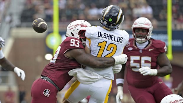 Kent State quarterback Dru DeShields is hit as he throws the ball by Florida State Seminoles defensive lineman Mandrell Desir