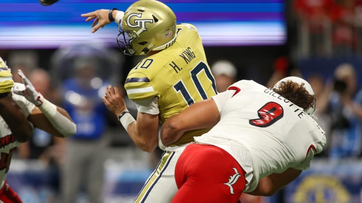 Sep 1, 2023; Atlanta, Georgia, USA; Georgia Tech Yellow Jackets quarterback Haynes King (10) is hit by Louisville Cardinals defensive lineman Ashton Gillotte (9) while throwing an interception in the first quarter at Mercedes-Benz Stadium.